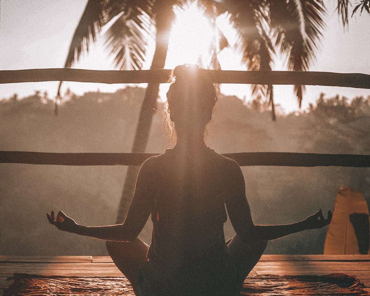 Silhouette seated in guided breathwork at golden hour